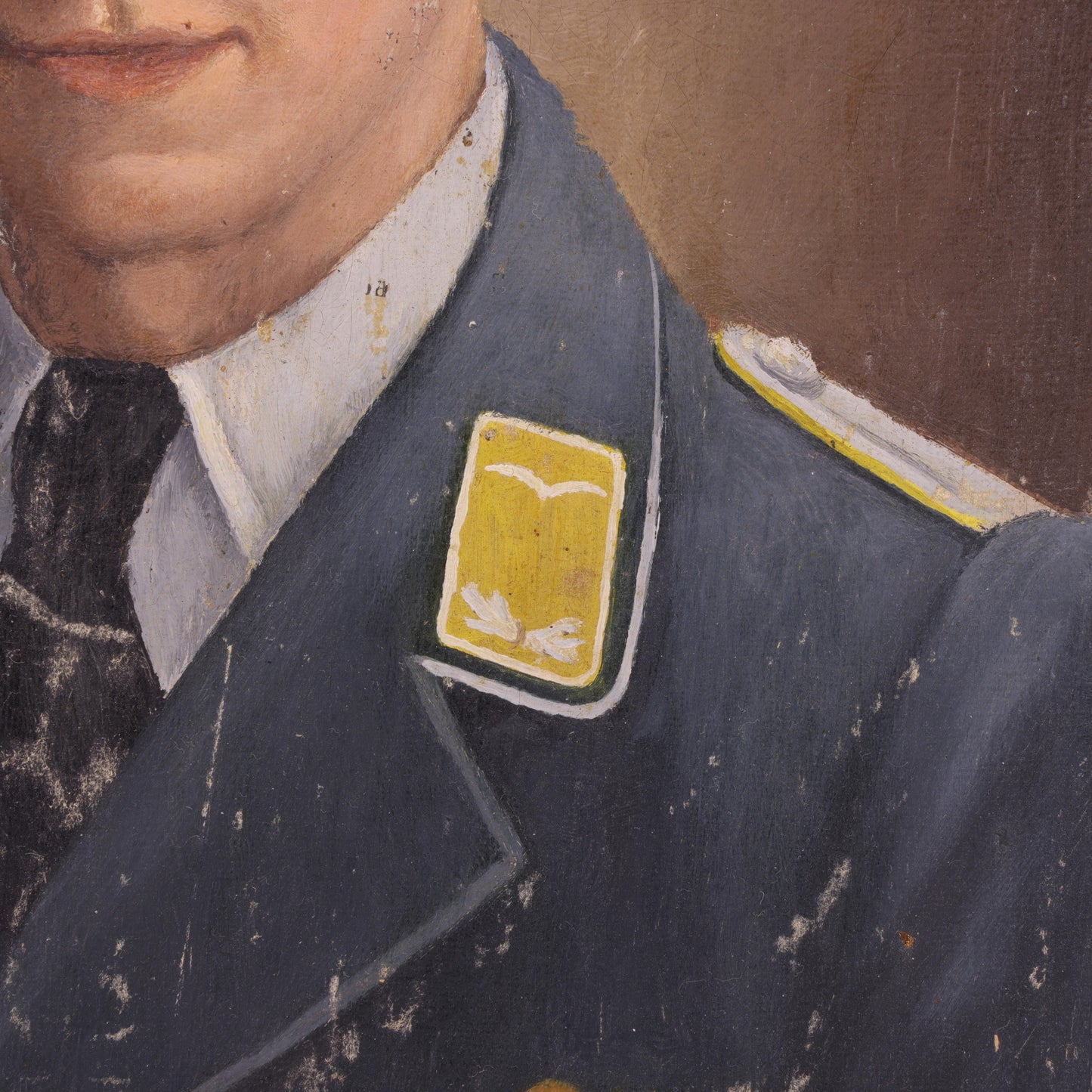 Close-up of a person wearing a dark blue uniform with a yellow patch on a brown background