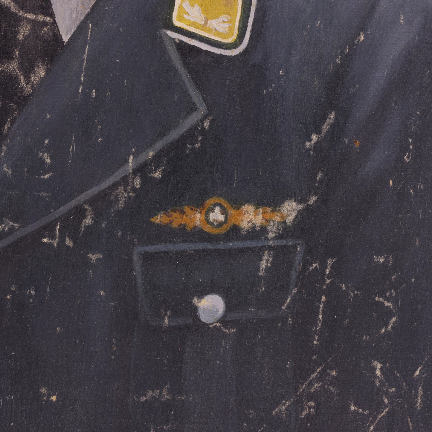 Close-up of a dark fabric with embroidered designs and a button.